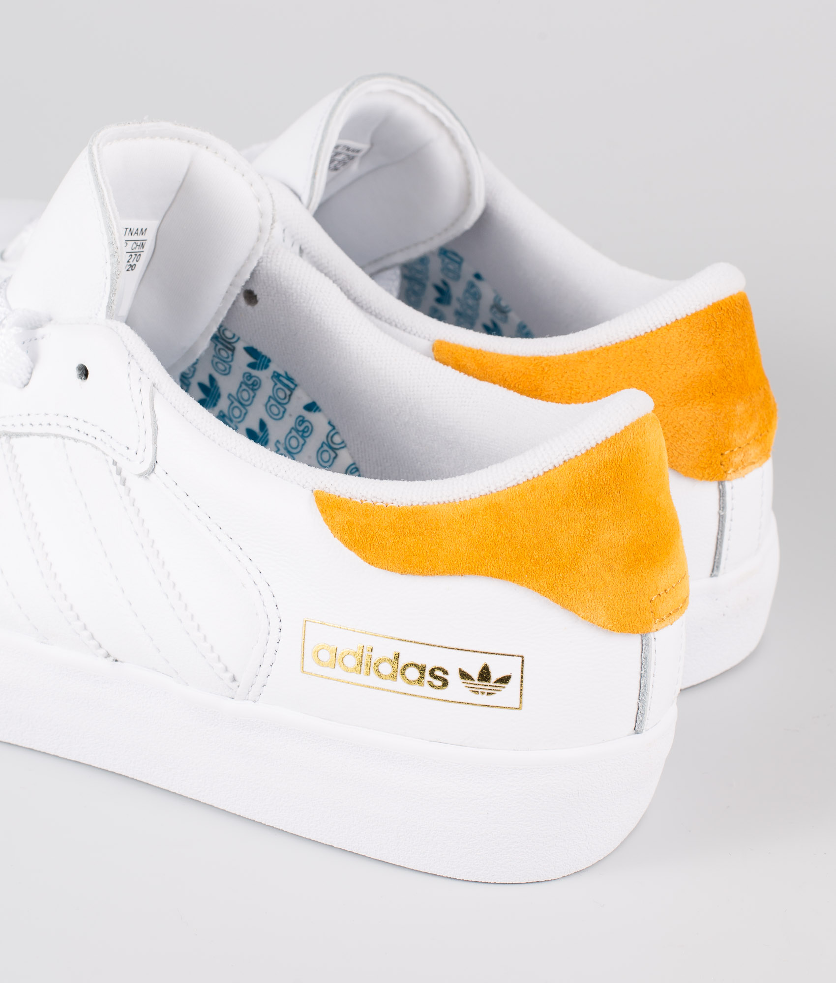 white and yellow adidas shoes